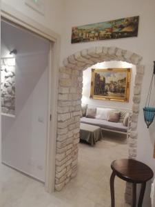 a living room with a stone archway with a couch at Terrazza Santoro per la vostra estate da sogno!!! in Vieste