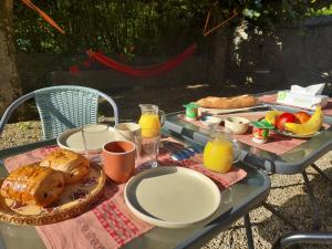 einen Picknicktisch mit Frühstückszutaten und Orangensaft in der Unterkunft Avol d'oiseau in Villers-Farlay