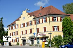 a large yellow building with a brown roof at White Midsommar - Stilvolle Wohnung, 4 Schlafzimmer, Küche in Landshut