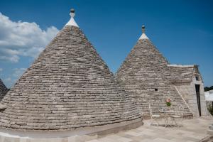 two large stone structures with tables and chairs at Trulli D'autore in Martina Franca