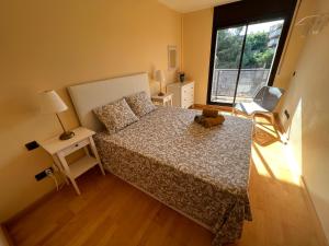 ein kleines Schlafzimmer mit einem Bett und einem Fenster in der Unterkunft La Chartreuse Apartament in Tarragona
