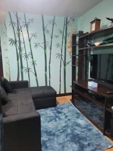 un soggiorno con divano, TV e murale in bambù di Tisa labangon condo a Labangon