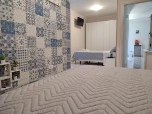 a bedroom with a large bed with a tiled wall at Midway House AMALFI COAST - POMPEI - SORRENTO COAST- NAPOLI in Sant'Egidio del Monte Albino