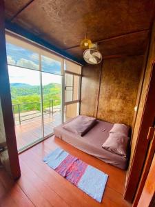 a bed in a room with a large window at Vaya House in Chiang Mai