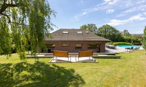 a house with a bench in the yard at Luxueuse et spacieuse villa avec sauna et piscine in Malmedy