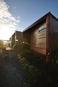 a wooden house with the sun setting behind it at Vaya House in Chiang Mai