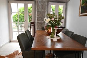 einen Esstisch mit einer Blumenvase darauf in der Unterkunft Holiday Home Villa Mavrici in Buzet