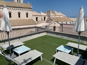 a patio with tables and umbrellas on a building at Sebèl Luxury Rooms in Barletta
