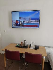 a dining room table with a television on it at New City Hotel Scheveningen in Scheveningen