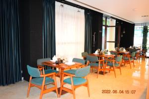 a dining room with wooden tables and blue chairs at Carpe Diem Apartments-Hotel in Shëngjin