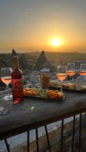 a table with glasses of wine and a plate of food at Wings Cappadocia in Uchisar