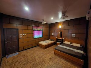 a large room with two beds and a window at Coral Bungalows in Haad Rin