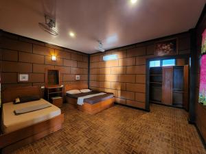 a bedroom with two beds in a room with brick walls at Coral Bungalows in Haad Rin