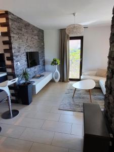 a living room with a couch and a tv at Lucia Exclusive with parking in the garage in Poreč