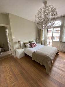 a bedroom with a large bed and a chandelier at Hasselt City Garden Duplex in Hasselt