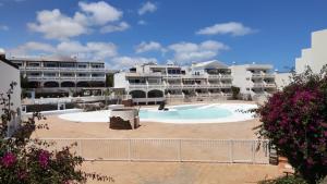 un gran edificio con una gran piscina frente a él en New Pistachio Apartment en Costa Teguise