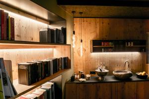 een bibliotheek met een wastafel en boeken op planken bij Bacher'stay in Bressanone