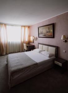a bedroom with a large bed and a window at Rovno Hotel in Vidin