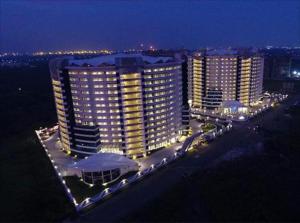 a large building lit up at night with lights at Homestays at Rajhans BELLIZA Near Airport in Surat
