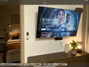 telewizor z płaskim ekranem wiszący na ścianie w obiekcie Alėjos Apartmentai City w Druskienikach