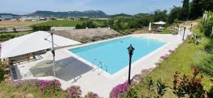 een groot zwembad in een veld met paarse bloemen bij Villa Poggio Ulivo Pool-Apartments in Rivoli Veronese