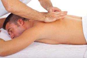 a man laying on a bed getting a massage at La cactée singulière in Béziers