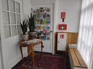 a hallway with a table and potted plants next to a door at VRYE HEERLYKHEYD ( adults only ) studio 2 in Middelburg