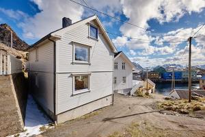 a white house sitting on the side of a street at Nyksund House Kapellbakken 3 bedrooms with sea view in Nyksund