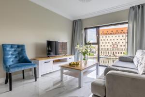 a living room with a couch and a tv at MIRA APARTMENTS in Gdańsk
