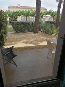 Elle offre une vue sur une terrasse dotée de chaises et d'une table. dans l'établissement BEIJA FLOR, au Cap d'Agde
