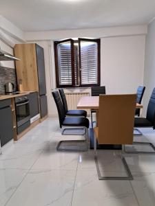 kuchnia i jadalnia ze stołem i krzesłami w obiekcie Sunset Apartment w mieście Jagodje