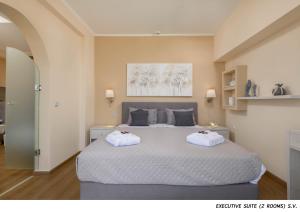 a bedroom with a large bed with two white towels at OLYMPOS BEACH HOTEL in Faliraki