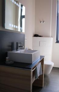 a bathroom with a white sink and a toilet at Hotel Stadthaus in Erlangen