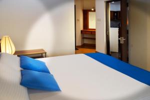 スリ・ジャヤワルダナプラ・コッテにあるGreat Location Living, Modern 2-Bed Apartment with Pool & Gym Access, All Amenitiesのベッドルーム(青い枕の大きな白いベッド付)