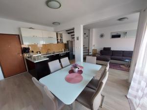 una sala da pranzo e una cucina con tavolo e sedie bianchi di Apartment Palada a Kaštela (Castelli)