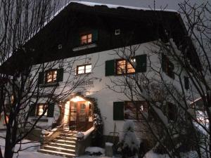 a white house with an entry way in the snow at Arlenheim in Sankt Anton am Arlberg