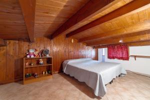 1 dormitorio con 1 cama en una habitación con paredes de madera en Il Prato degli Ulivi, en Rocca Imperiale