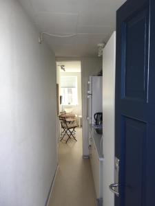 a hallway with a door and a kitchen with a table at Rebslagerhuset in Ribe