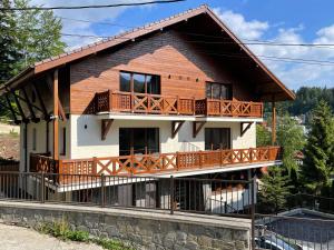a house with a large deck on the side of it at PENTA Apartments in Sinaia