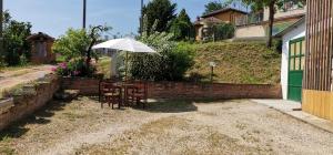 a table and chairs with an umbrella in a yard at Casa Mondorosso in Crocetta