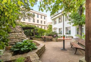 a courtyard with benches and a stone wall at Hotel Museum in Prague