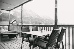 a table and chairs on a balcony with a view of a mountain at Chalet Village by Apart4you in Ramsau am Dachstein