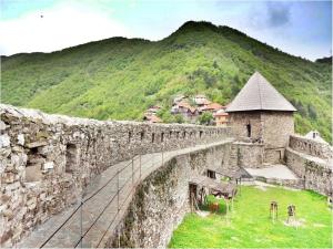 a stone wall with a mountain in the background at sweet home in Nemila