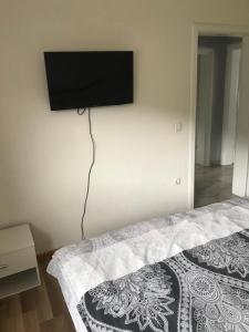 1 dormitorio con 1 cama y TV de pantalla plana en la pared en sweet home, en Nemila