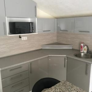 a kitchen with a microwave and a sink at sweet home in Nemila +4 photos