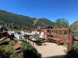 un patio con mesa, sillas y una valla en Hotel Roc de St Miquel & Apartment, en Soldeu