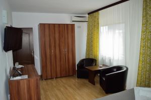 a room with two chairs and a table and a wooden door at Helen Rooms Vama Veche in Vama Veche