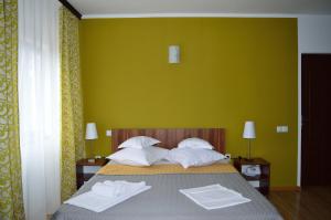 a bedroom with a bed with two white towels on it at Helen Vama Veche in Vama Veche