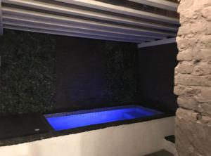 a swimming pool with a blue light in a room at Pequeño Alojamiento con Mini Piscina - NO climatizada in Valencia