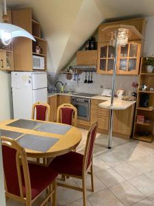 kuchnia z drewnianym stołem i krzesłami oraz stołem i kuchnia z w obiekcie Buborék Apartman w Hajduszoboszlo